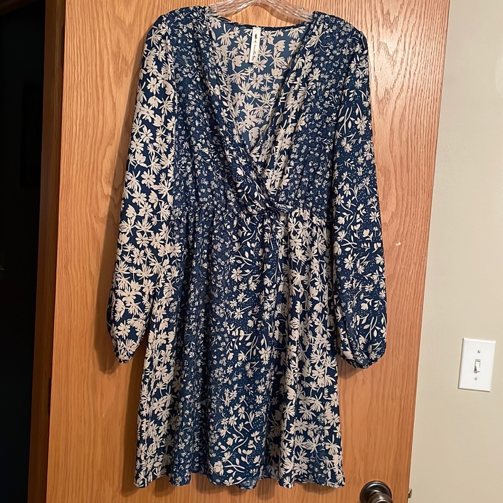 This vanilla baby dress has an elastic waist and long sleeves